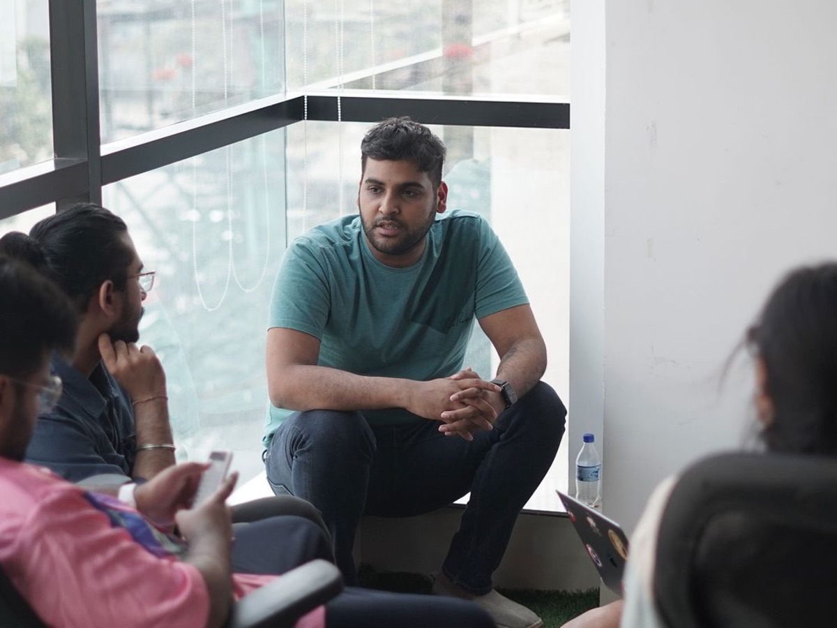 Adesh mid-discussion with the team gathered around him in the office